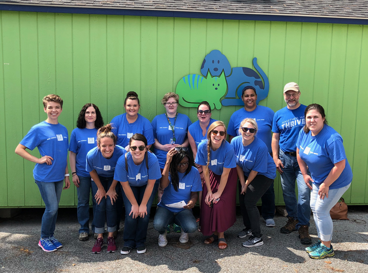 ORNL team members smiling and wearing shirts that say Together We Thrive